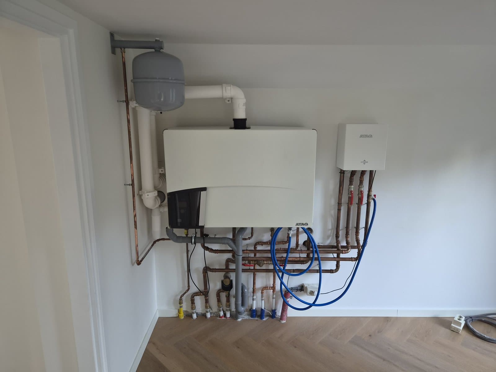 Overzicht van ATAG hybride installatie in de hoek van een ruimte